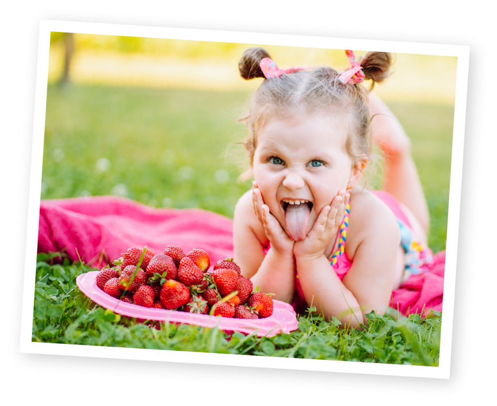 Child picking strawberries at over farm